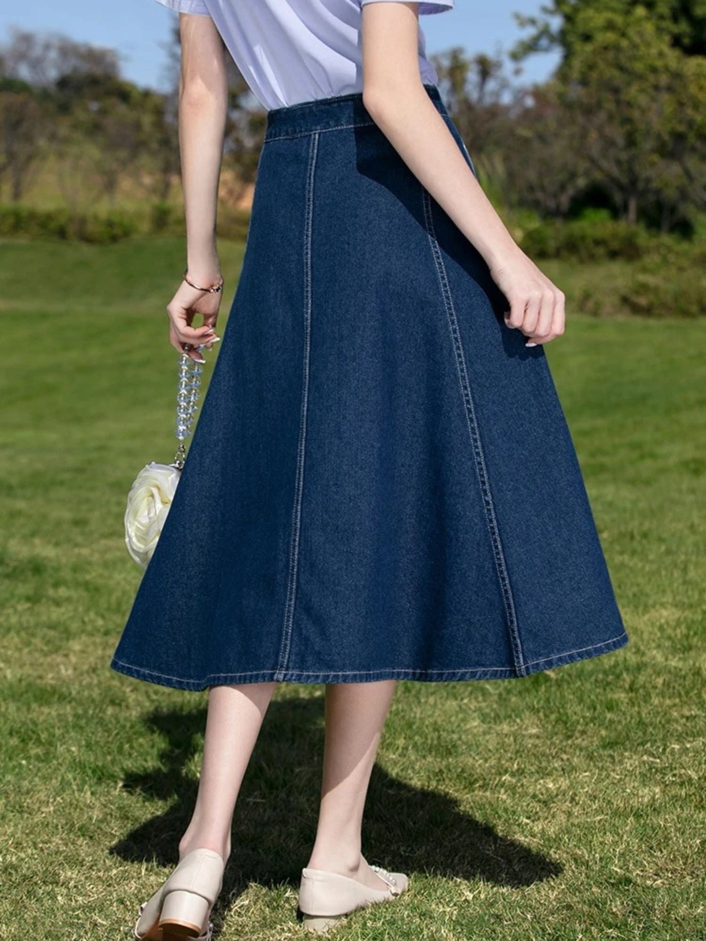 A woman wearing a vintage high waisted denim midi skirt.