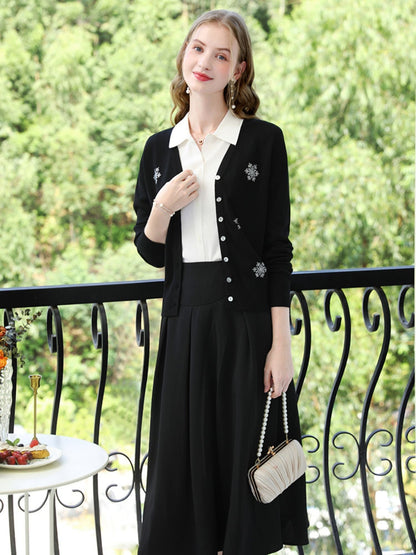 A woman wearing a v-neck cardigan with snowflakes embelishments.