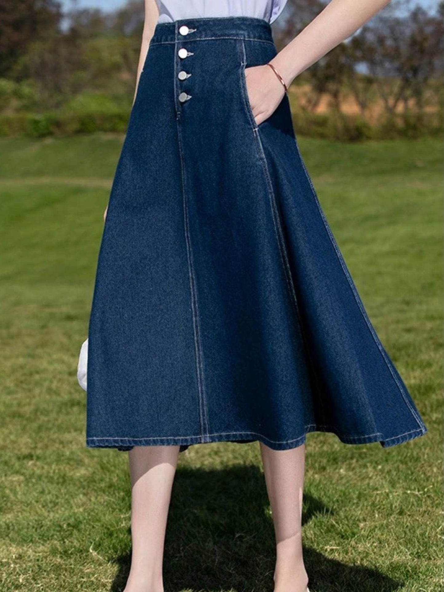 A woman wearing a vintage high waisted denim midi skirt.