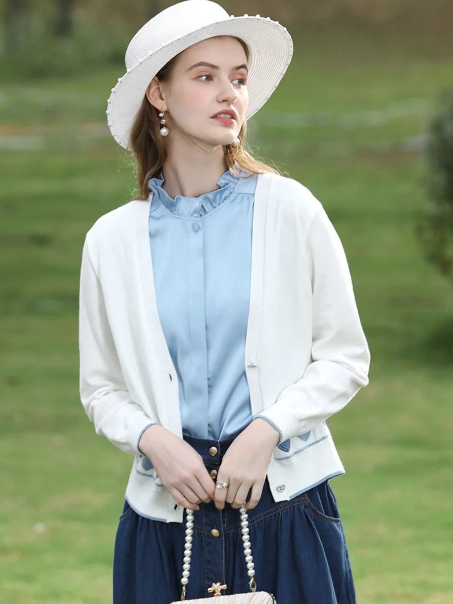 A woman wearing a sleeveless blouse with a ruffled collar design.