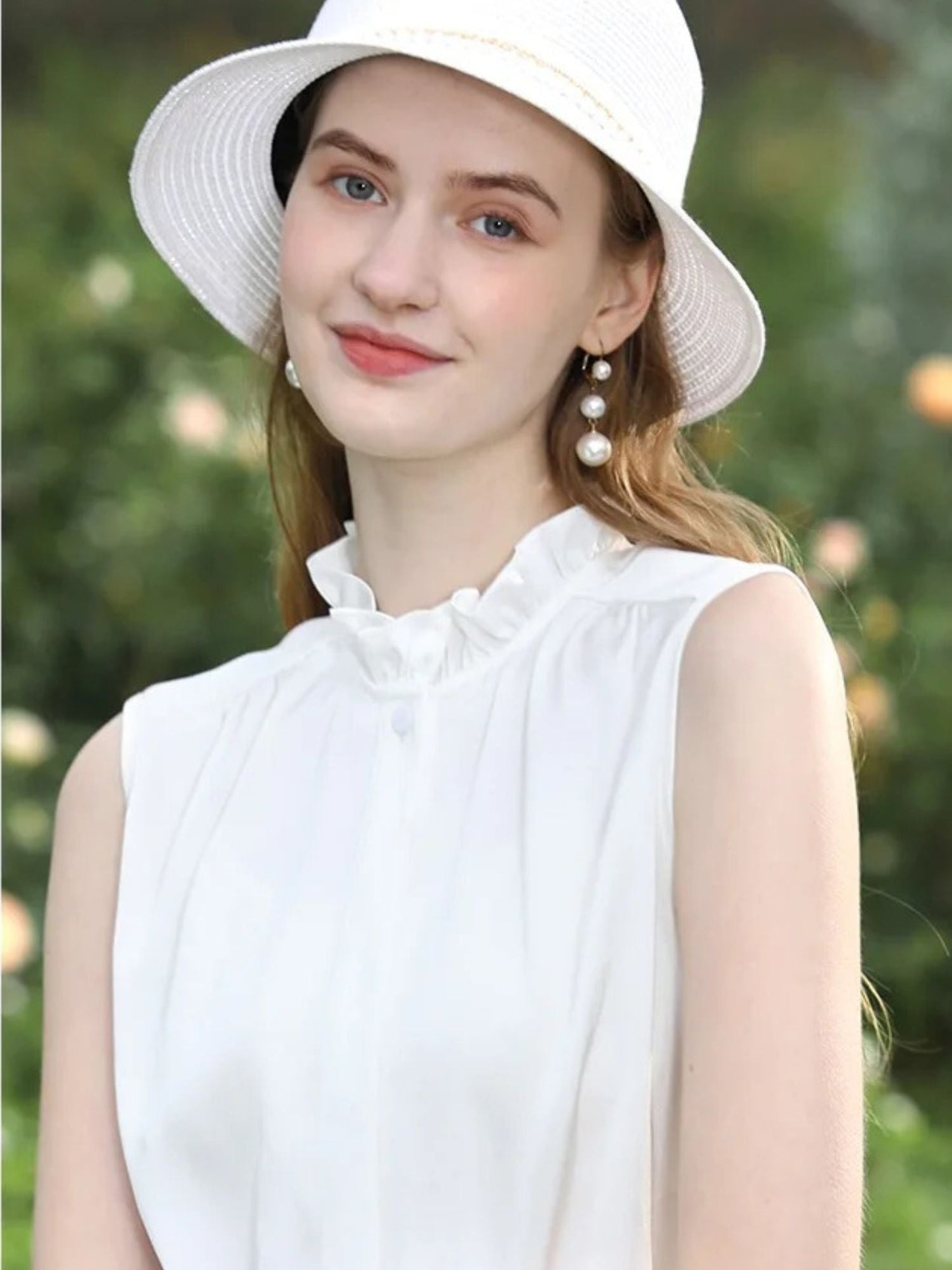 A woman wearing a sleeveless blouse with a ruffled collar design.