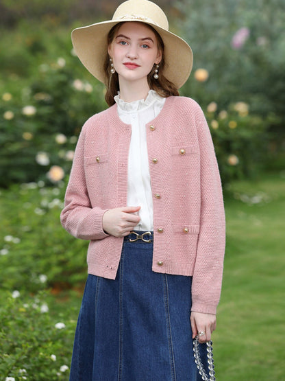A woman wearing a tweed knit cardigan.