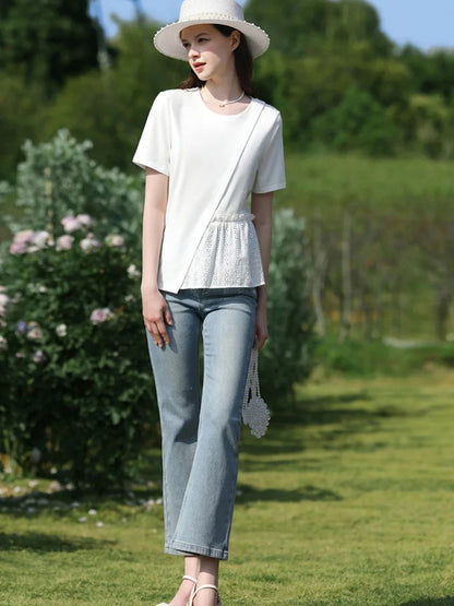 A woman wearing a pleated t-shirt with eyelet details.