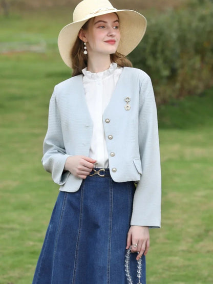 A woman wearing a sleeveless blouse with a ruffled collar design.