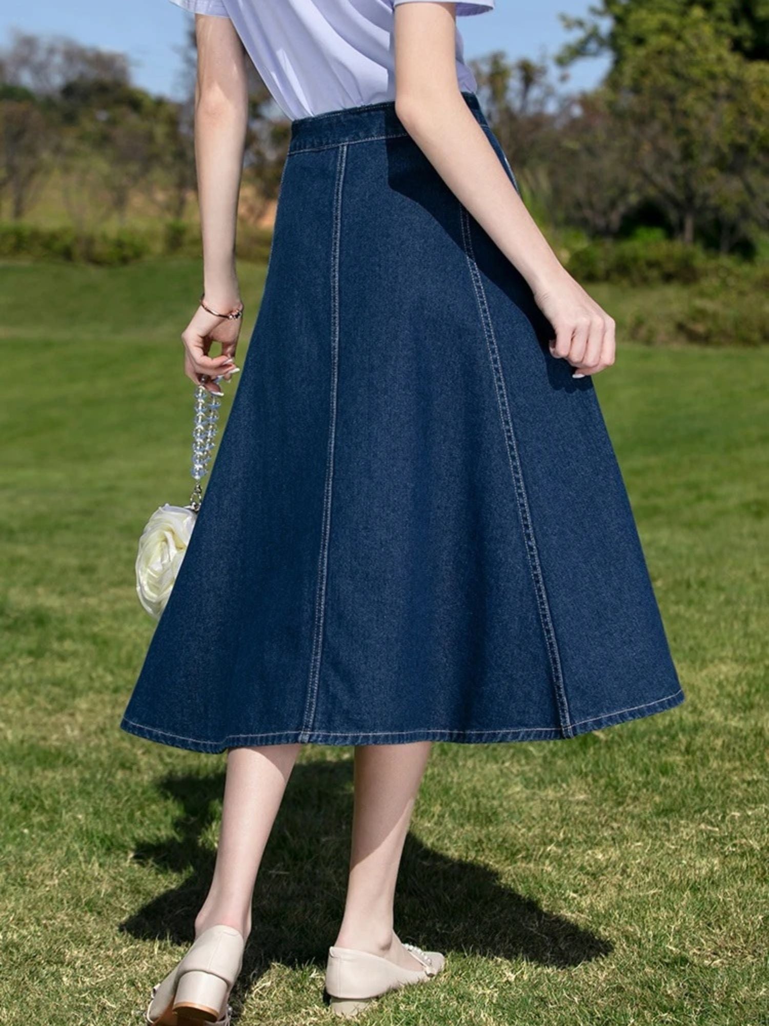 A woman wearing a vintage high waisted denim midi skirt.