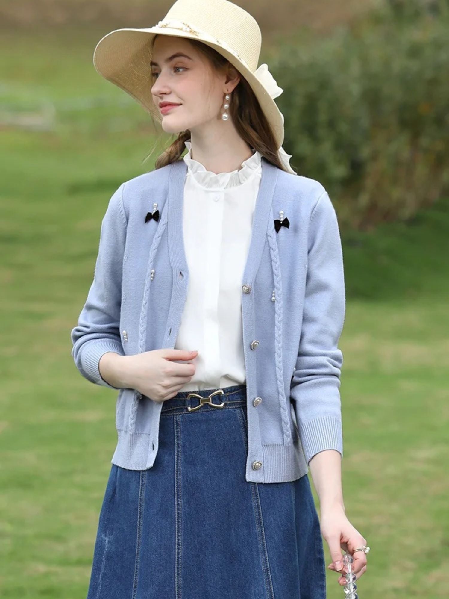 A woman wearing a sleeveless blouse with a ruffled collar design.
