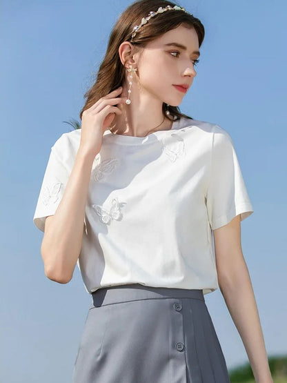 A woman wearing a summer t-shirt with a butterfly embroidery.