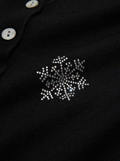A woman wearing a v-neck cardigan with snowflakes embelishments.