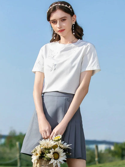 A woman wearing a summer t-shirt with a butterfly embroidery.